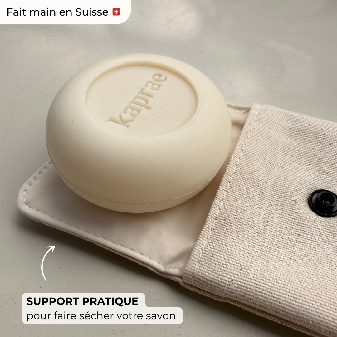 Savon Kaprae au lait de chèvre posé sur une pochette en tissu beige, accessoire pratique pour faire sécher le savon.