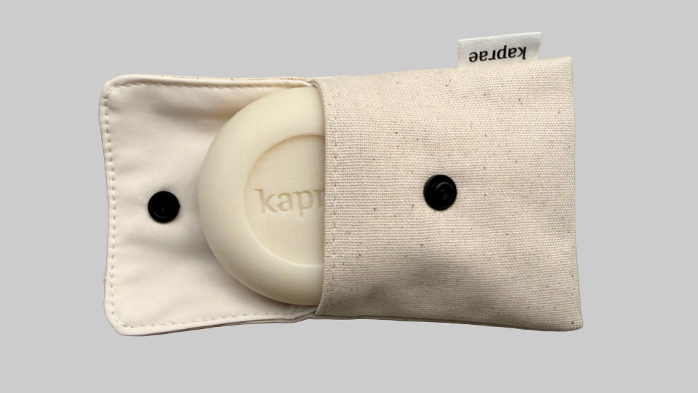 Savon Kaprae au lait de chèvre rangé dans une pochette en tissu beige imperméable, faite main en Suisse. Image