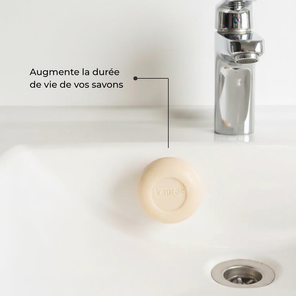 Porte-savon aimanté Kaprae fixé sur un lavabo blanc, permettant au savon de sécher et de durer plus longtemps.